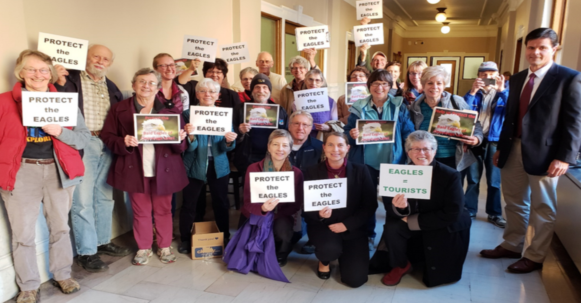 people holding save birds signs