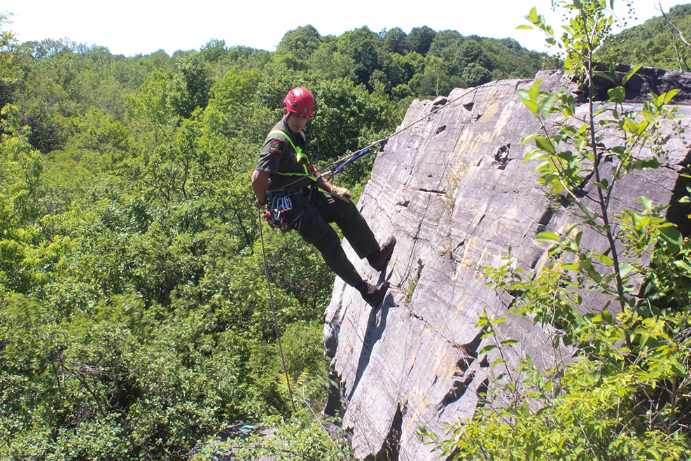 ranger scaling a cliff