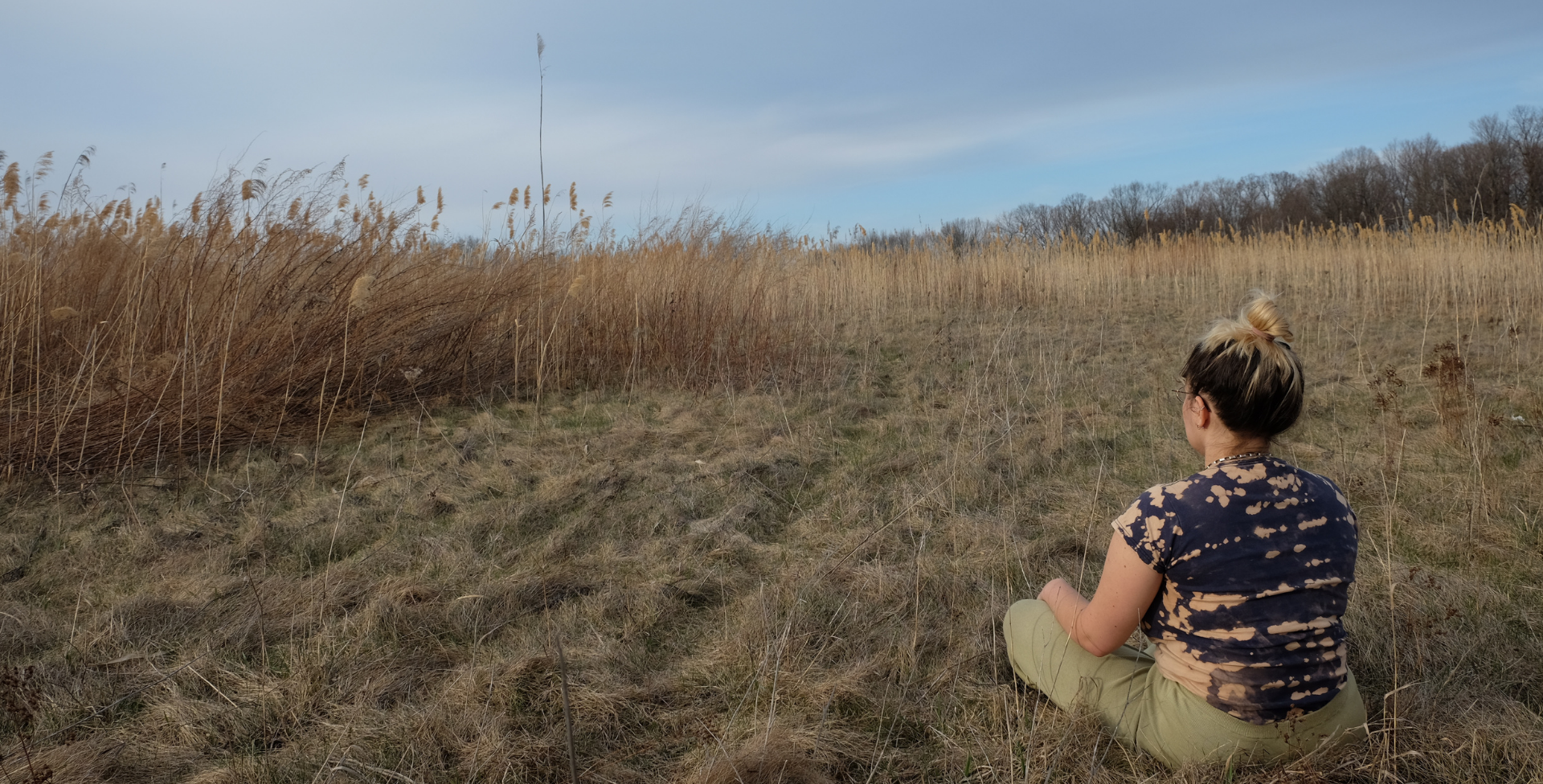 Woman sitting in grass meditating